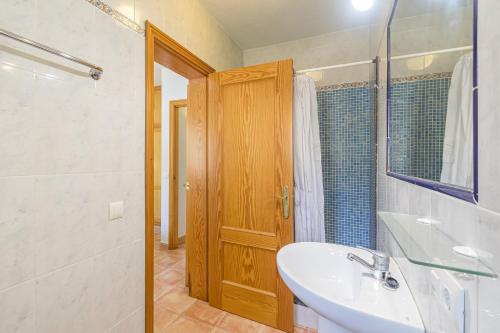 a bathroom with a sink and a wooden door at Villa Novas Park in Son Parc