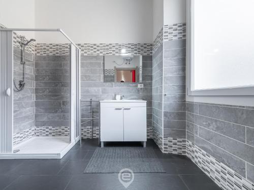 a bathroom with a white sink and a shower at Manì Rooms Villanova in Cagliari