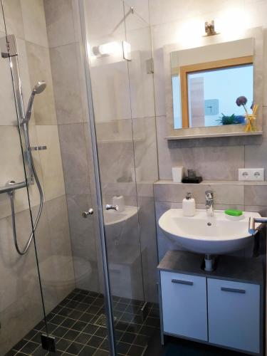uma casa de banho com um lavatório e um chuveiro em **Auszeit am Kaiser** em Walchsee