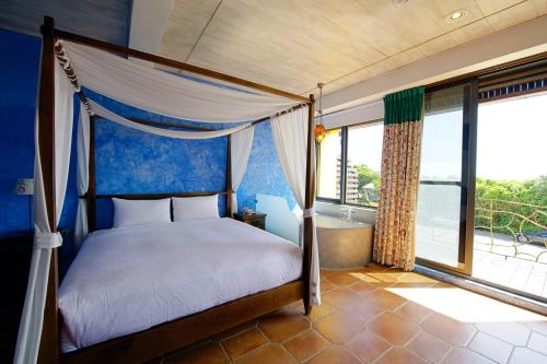 a bedroom with a canopy bed and a tub and windows at 砂點民宿 in Eluan