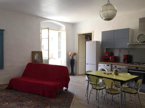 a living room with a red couch and a table at Casa Mariana in Ghisoni