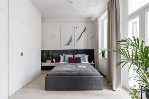 1 dormitorio con 1 cama en una habitación con paredes blancas en Apartments Factory, en Sopot