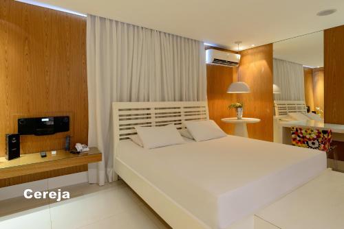 1 dormitorio con 1 cama blanca grande y TV en Apple Motel ( Adults Only ) en São Paulo