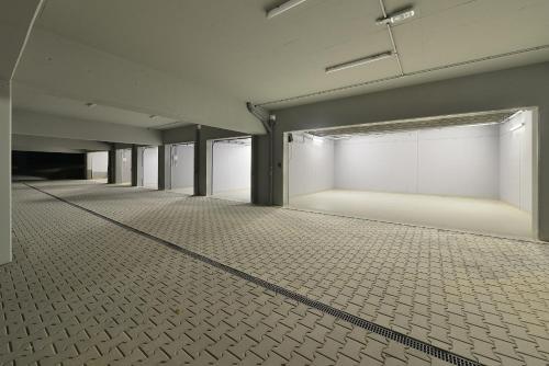 an empty room with white walls and a tiled floor at Element Lakeside Apartments in Lipno nad Vltavou