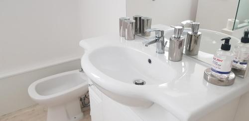 a white bathroom with a sink and a toilet at San Carlos mer in Saint-Jean-de-Luz