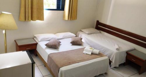 Zimmer mit 2 Betten und einer Lampe in der Unterkunft Hotel São Paulo Inn in Santa Rita do Passa Quatro