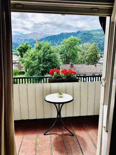 a small table on a balcony with a view at Gästehaus Hohe Tannen in Garmisch-Partenkirchen