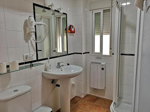 a white bathroom with a sink and a shower at Mirador de la Campiña in Cazorla