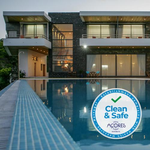 a sign in front of a building with a swimming pool at São Vicente Lodge - Panoramic Retreat in Capelas
