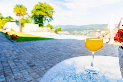 a glass of wine sitting on top of a table at Casa d' Avó Marcelina - Casas de Campo in Arcos de Valdevez