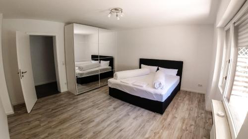 1 dormitorio con cama y espejo grande en Private and cozy Apartment in Refrath near Cologne, en Bergisch Gladbach