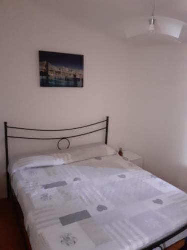 - un lit dans une chambre avec une photo sur le mur dans l'établissement Casa vacanze azzurra, à Montemerano