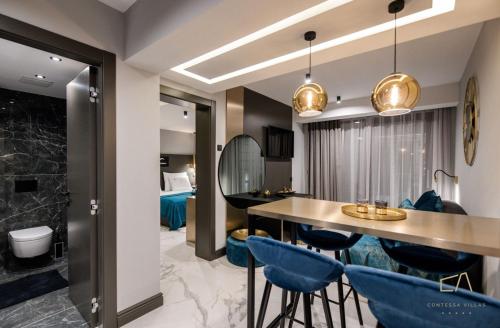 a living room with a dining room table and blue chairs at Luxury Apartments in Villa Curiera in Malinska