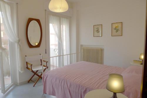 ein Schlafzimmer mit einem Bett, einem Spiegel und einem Stuhl in der Unterkunft Casa Stefania Igea Marina Vista Mare in Bellaria-Igea Marina
