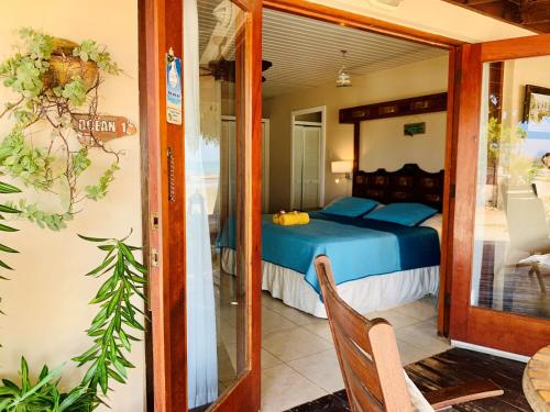 a bedroom with a bed and a glass doorway at Aruba Sunset Beach Studios in Palm-Eagle Beach