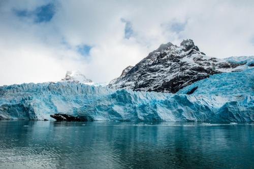 a large iceberg in the water with a mountain at Mirador del Lago Hotel in El Calafate