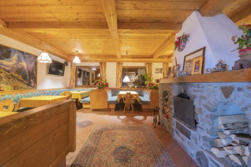 a large living room with a stone fireplace at Hotel Rascard in Valtournenche