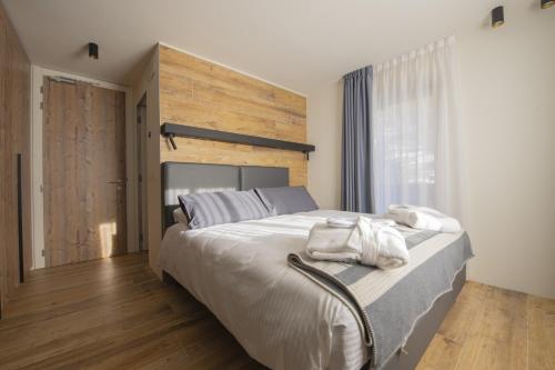 a bedroom with a large bed with towels on it at Hotel Rascard in Valtournenche