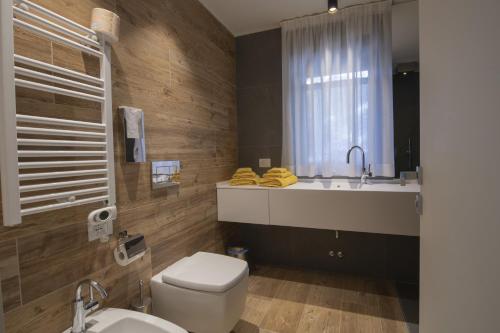 a bathroom with a white toilet and a sink at Hotel Rascard in Valtournenche