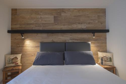 a bedroom with a large bed with a wooden wall at Hotel Rascard in Valtournenche