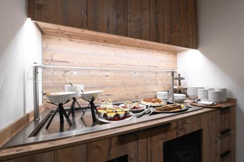 a buffet with many different types of food on a counter at Hotel Rascard in Valtournenche