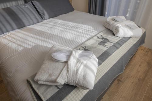 a bed with two towels and two towels at Hotel Rascard in Valtournenche