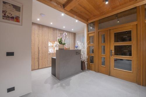 a hallway with wooden doors and a counter in a room at Hotel Rascard in Valtournenche