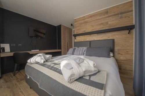 a bedroom with a bed with towels on it at Hotel Rascard in Valtournenche
