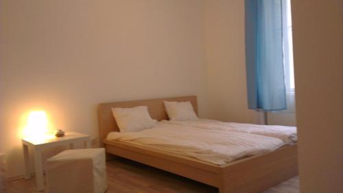 Un pequeño dormitorio con una cama y una lámpara en una mesa. en Apartman 4 you, en Budapest