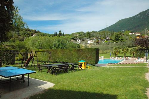 a backyard with picnic tables and a swimming pool at Park Hotel Val Di Monte ***S in Malcesine
