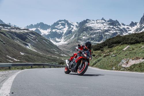 a person riding a red motorcycle on a mountain road at Aparthotel Lerch in Kappl