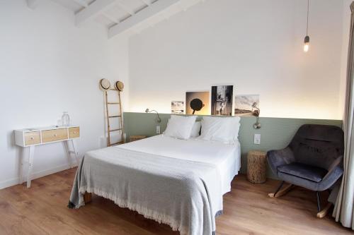 a bedroom with a bed and a chair at Mon hotel in Ciutadella