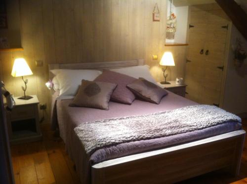 a bedroom with a bed with pillows and two lamps at Les Charmettes in Honfleur