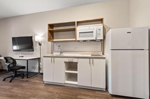 a kitchen with a white refrigerator and a desk at Extended Stay America Premier Suites - Tampa - Gibsonton - Riverview in Gibsonton
