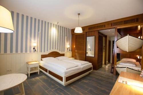 een slaapkamer met 2 bedden, een tafel en een bureau bij 4-Sterne Superior Erlebnishotel Bell Rock, Europa-Park Freizeitpark & Erlebnis-Resort in Rust