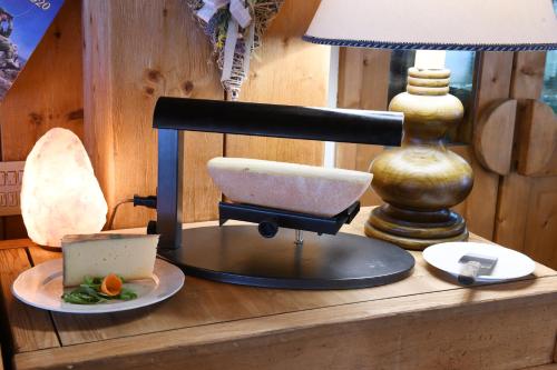 a table with a scale and a lamp on it at Hotel Rascard in Valtournenche