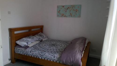 a small bedroom with a bed with a pillow and a picture at Worcester Town Home & Garden in Hindlip