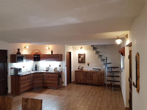 uma grande cozinha com armários de madeira e uma escadaria em Sklep u Čejků em Mutenice