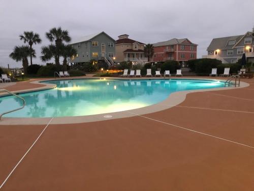 a swimming pool at night with chairs and houses at Gulf Shores Plantation in Gulf Shores