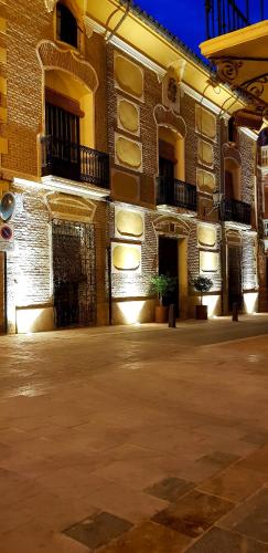 a large brick building with a courtyard in front of it at La Casa de los Coy in Mula