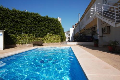 a swimming pool with blue water in front of a building at 17 Calle Lepanto in Benidorm