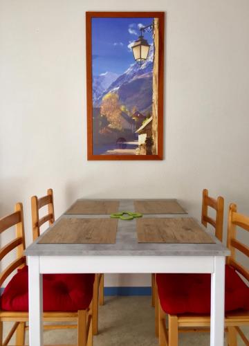 une table avec deux chaises et un tableau sur le mur dans l'établissement Appartement-Terrasse 