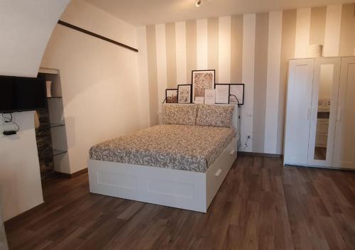 una camera con un letto in una stanza con pavimenti in legno di C'era una volta Appartamento OPEN SPACE Sestri Levante a Sestri Levante