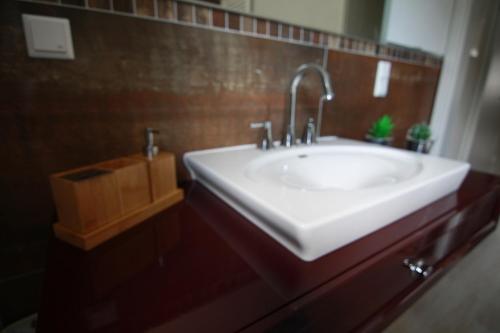 a bathroom with a white sink and a brown tiled wall at harz-traum.2 in Gernrode - Harz