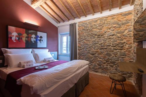 a bedroom with a bed with a stone wall at Monna Caterina Wine Resort in Vinci