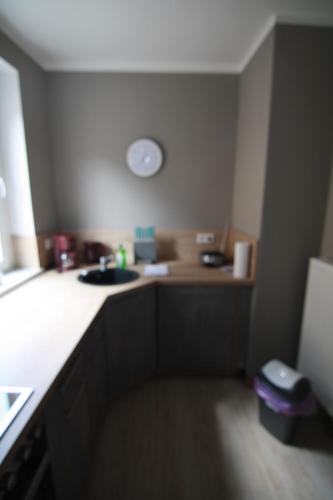 a kitchen with a sink and a clock on the wall at harz-traum.2 in Gernrode - Harz