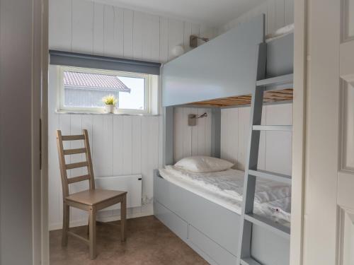a small bedroom with a bunk bed and a chair at Hav & Logi Skärhamn in Skärhamn