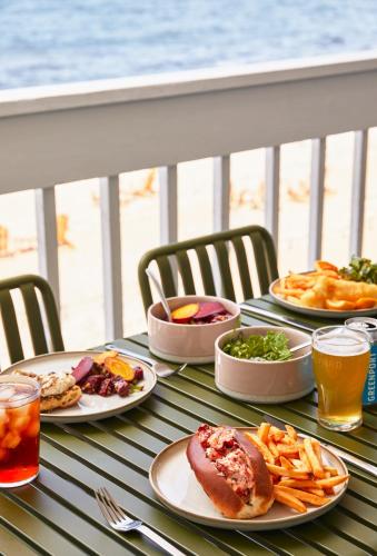 a table with plates of food and drinks on a balcony at Sound View Greenport in Greenport