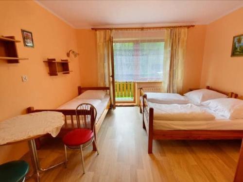 1 Schlafzimmer mit 2 Betten und einem Fenster in der Unterkunft D.W MAGURKA in Rycerka Górna
