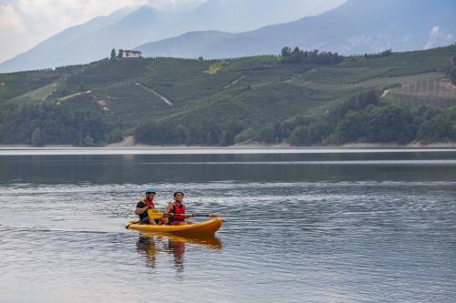 two people are in a kayak on a lake at Miraval Hotel in Coredo
